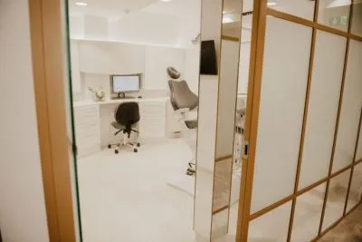 Treatment room behind brass-framed glazing at Blossom Cosmetic Clinic, York