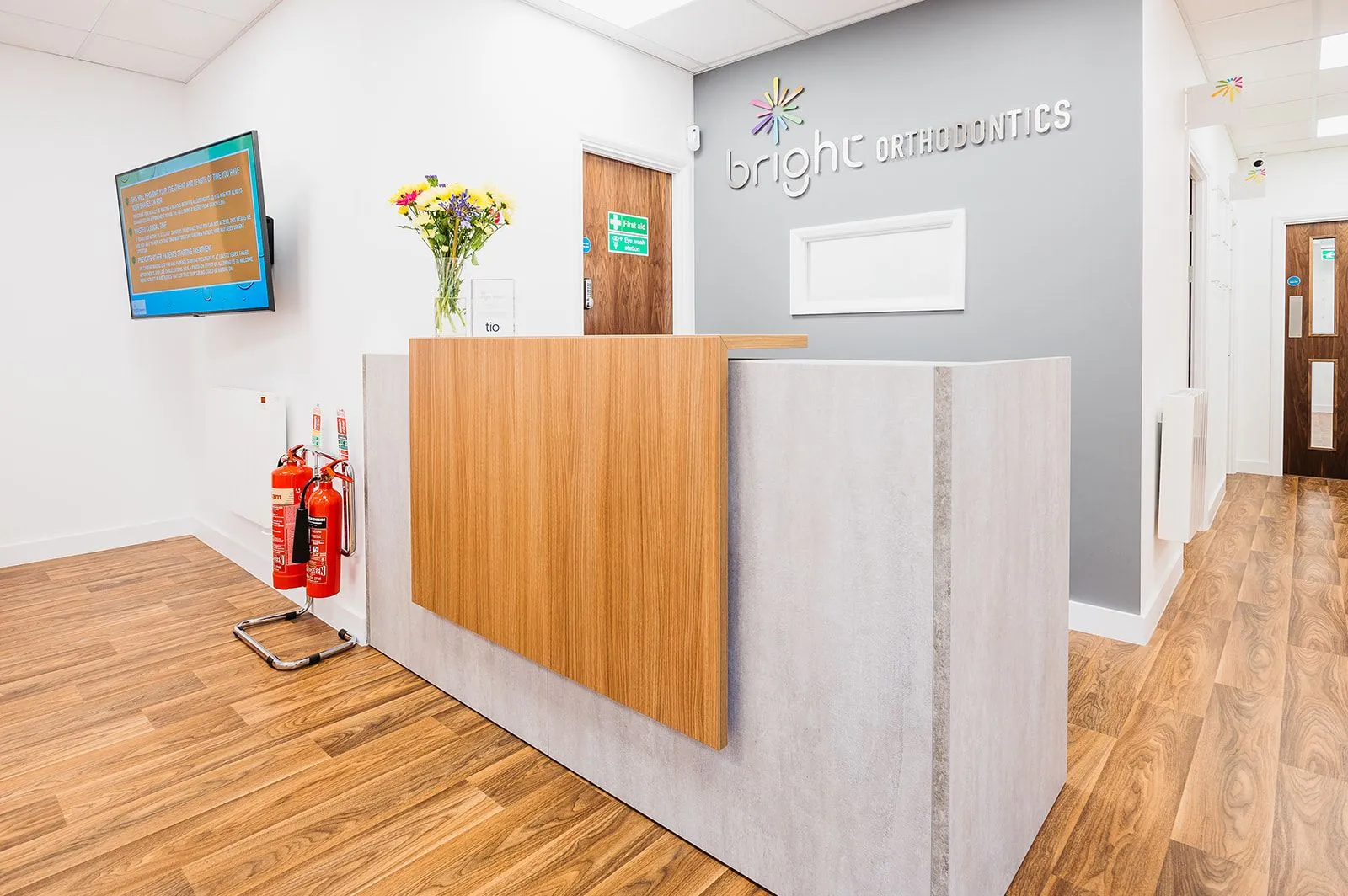 Reception desk with flowers and branded signage at Bright Orthodontics, Warrington